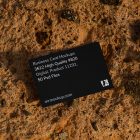 View from above, single outdoor business card mockup with blue and black colors, strong typography design, laying on massive stone.