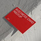 View from above, outdoor business card mockup with red and white colors, geometric typography design laying on the white color concrete.