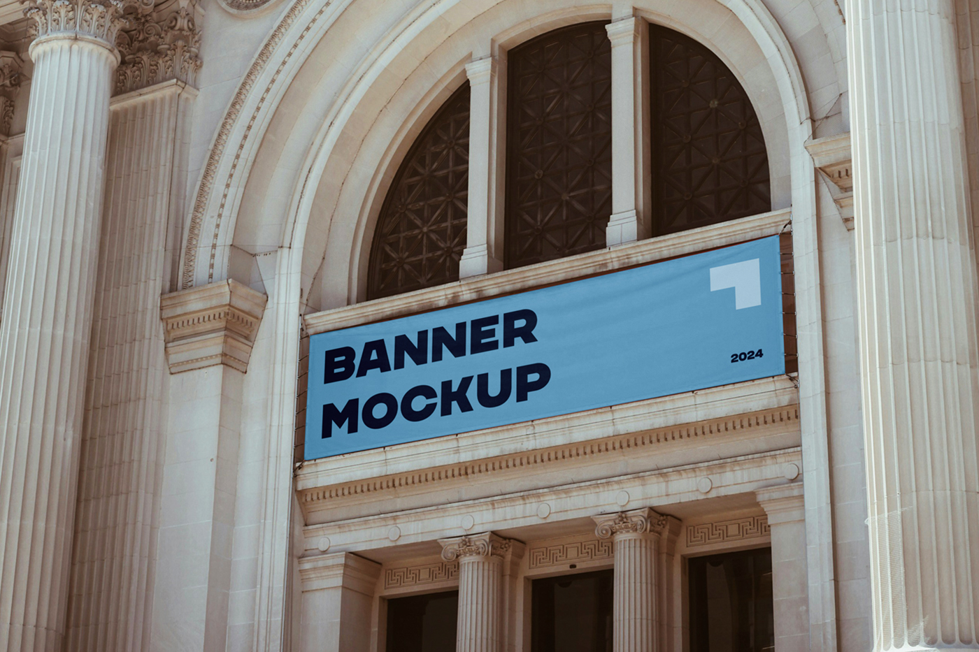 Hanging blue horizontal banner mockup over the entry to the art gallery building.