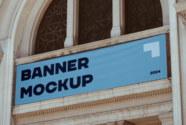 Hanging blue horizontal banner mockup over the entry to the art gallery building.
