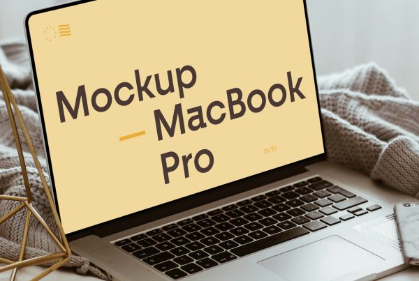 Side view, open silver MacBook Pro Mockup with decoration accessories laying in the bedroom.