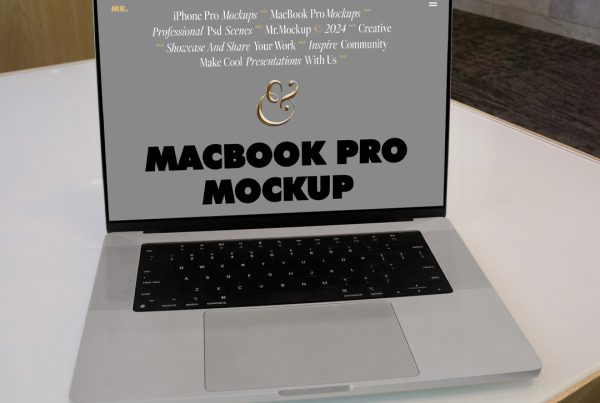Front view, open silver MacBook Pro Mockup laying on the white table at the office.