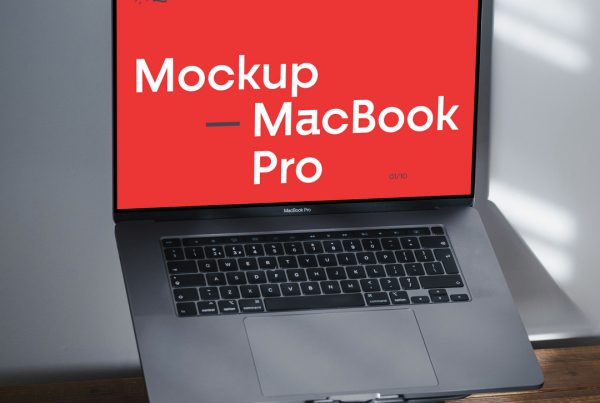 Front view, open silver MacBook Pro Mockup laying on the dark wooden desk.
