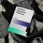 View from above, outdoor magazine mockups with three gradient shades and strong typography design, lying on a massive stone.