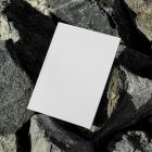 View from above, white outdoor magazine mockup lying on a massive stone.