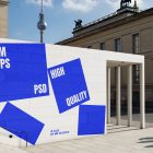 Front view, Wall Mockup with white and blue design before museum buildings. Scene from our Museum Mockups product.