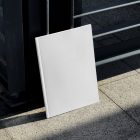 Front view, a white outdoor magazine mockup resists on a metal fence in black color.
