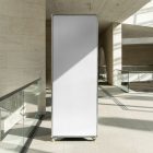 Front view, Vertical White Stand Mockup standing inside the modern architecture building. Scene from our Museum Mockups product.