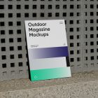 Front View, Outdoor Magazine Mockup with three gradient shades and strong typography design resists on concrete wall with square pattern.