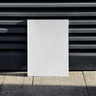 Front view, a white outdoor magazine mockup resists on a metal fence in black color.