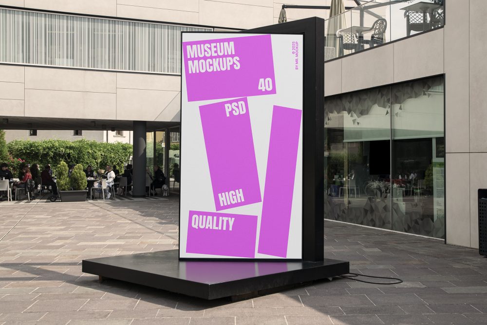 Front view, Vertical Billboard Mockup with white and pink design attached to the black metal landing. In the background you can see people sitting at tables. Scene from our Museum Mockups product.