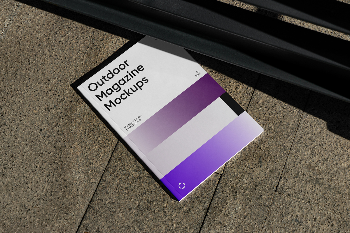 View from above of an Outdoor Magazine Mockup with three gradient shades and strong typography design lying on marble under a metal fence in black color.