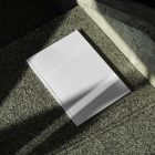 View from above of a white outdoor magazine mockup lying on marble.