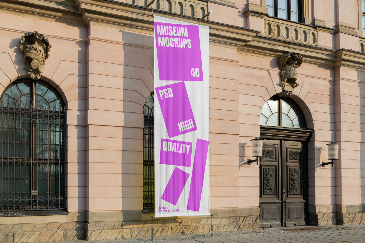 Front view, Hanging Vertical Banner Mockup with white and pink design attached to the silver pole in front of the old building elevation. Scene from our Museum Mockups product.