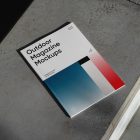 View from above of an Outdoor Magazine Mockup with three gradient shades and strong typography design lying on concrete stairs.