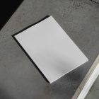 View from above of a white outdoor magazine mockup lying on concrete stairs.