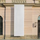 Front view, Hanging Vertical White Banner Mockup attached to the silver pole in front of the old building elevation. Scene from our Museum Mockups product.