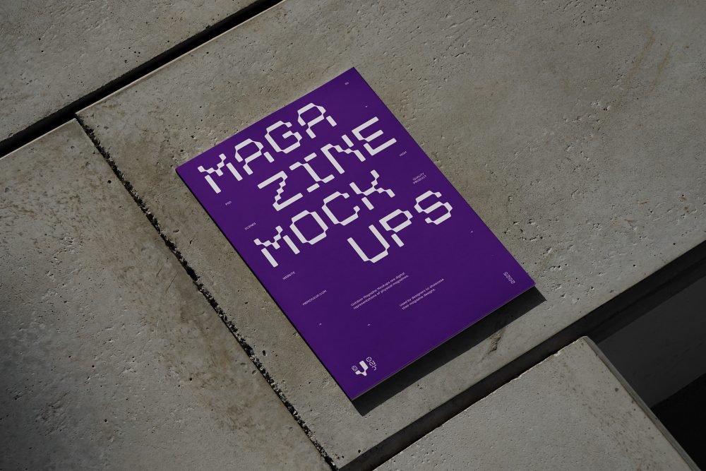 View from above of an Outdoor Magazine Mockup with strong purple typography design lying on concrete slabs.