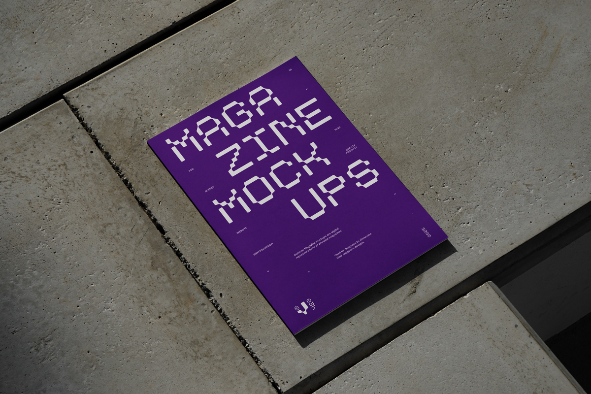 View from above of an Outdoor Magazine Mockup with strong purple typography design lying on concrete slabs.