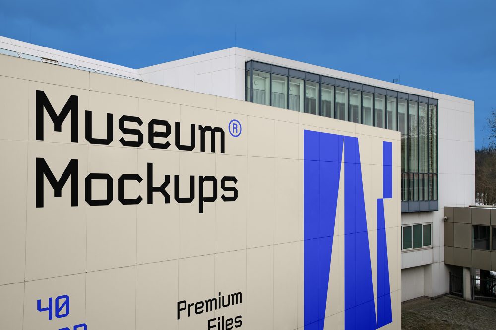 View from above, Wall Mockup with black, beige, and purple geometric design in front of the building with huge vertical windows. Scene from our Museum Mockups product.