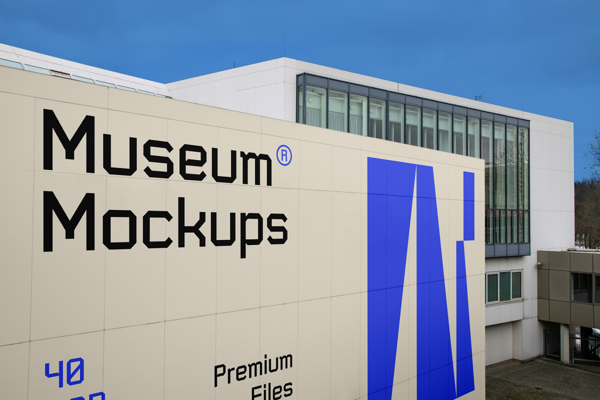 View from above, Wall Mockup with black, beige, and purple geometric design in front of the building with huge vertical windows. Scene from our Museum Mockups product.