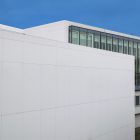 View from above, White Wall Mockup in front of the building with huge vertical windows. Scene from our Museum Mockups product.