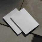 View from above of two white outdoor magazine mockups lying on concrete slabs.