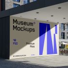 Front view, Wall Mockup with beige, black, and purple geometric design in front of the buildings. Scene from our Museum Mockups product.