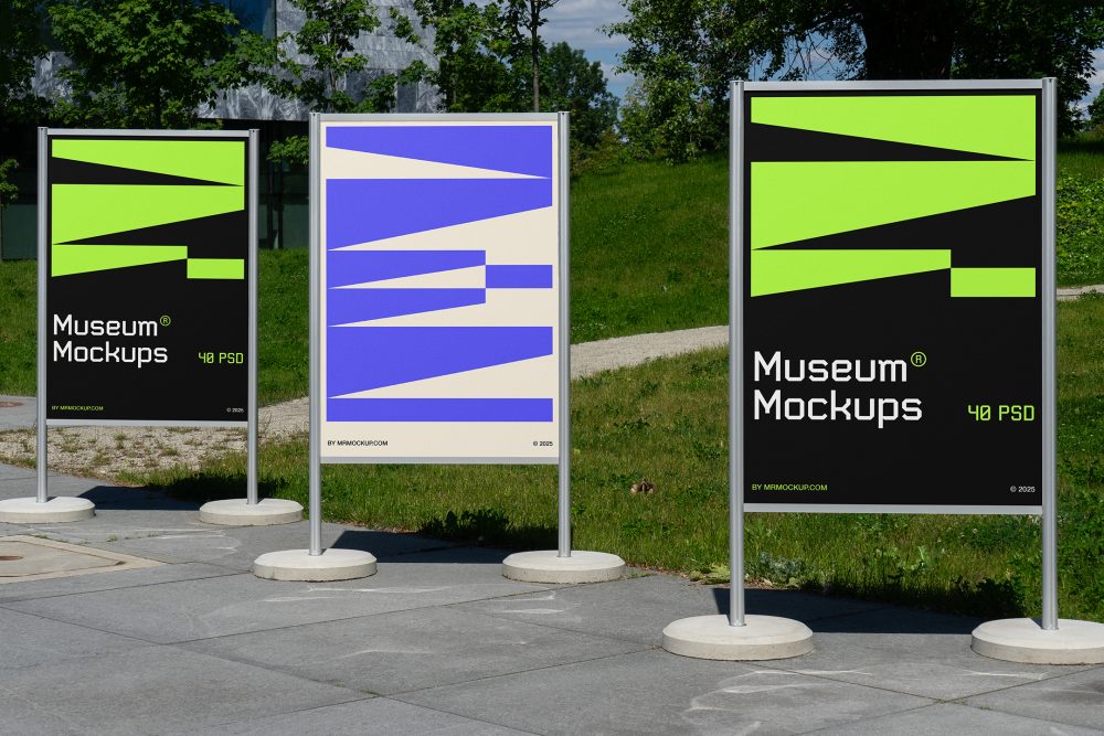 Front view, Three Poster Mockups with white, black, beige, and purple geometric designs standing on the side wall in front of the city park. Scene from our Museum Mockups product.