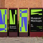Front view, Four Vertical Poster Mockups with white, black, purple, and neon green geometric designs standing in front of the old building. Scene from our Museum Mockups product.