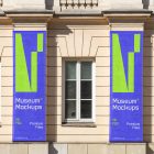 Front view, Two Hanging Banner Mockups with white, purple, and neon green geometric designs on an old building elevation. Scene from our Museum Mockups product.