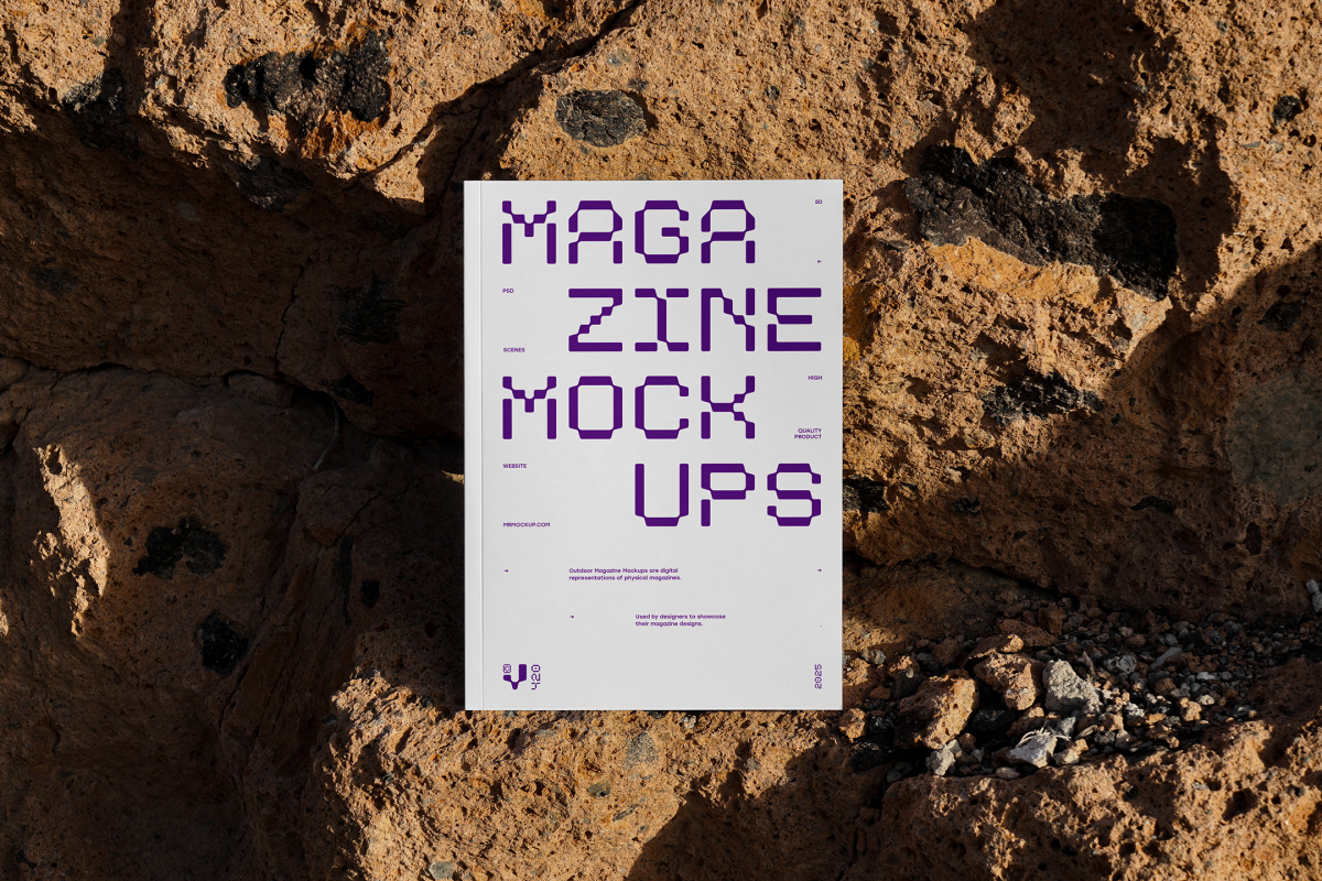 Front view, outdoor magazine mockup with strong purple typography design standing on the boulders.