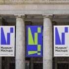 Front view, Three Hanging Banner Mockups with white, purple, and neon green geometric designs on an old building elevation, just above the entrance. Scene from our Museum Mockups product.
