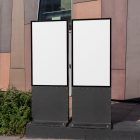 Front view, Two White Poster Mockups standing in front of the modern architecture building. Scene from our Museum Mockups product.