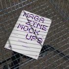 View from above of outdoor magazine mockups with strong purple typography design lying in the shopping cart.