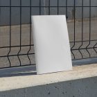 Front view, of a white outdoor magazine mockup resists on metal net fence in black color.