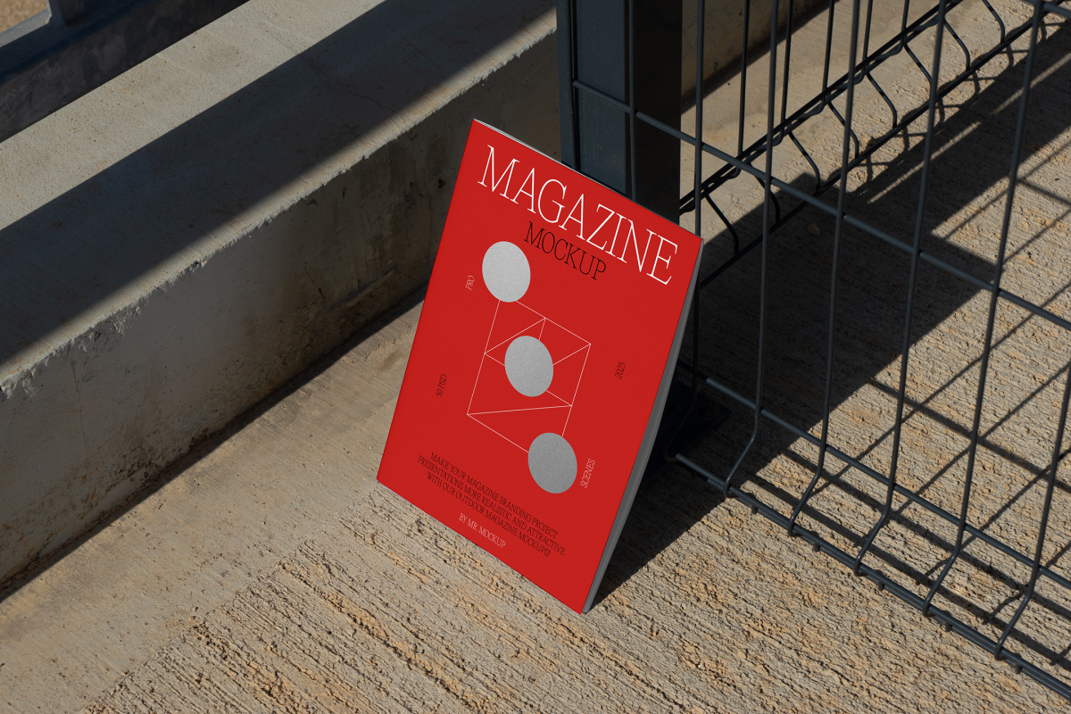 Front view, of outdoor magazine mockups with simple minimalist design in white and red colors, serif typography, and circle foil pattern resists on a metal net fence in black color.