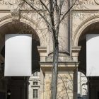 Front view, Two White Hanging Banner Mockup holding on to ropes attached to the building. Scene from our Museum Mockups product.