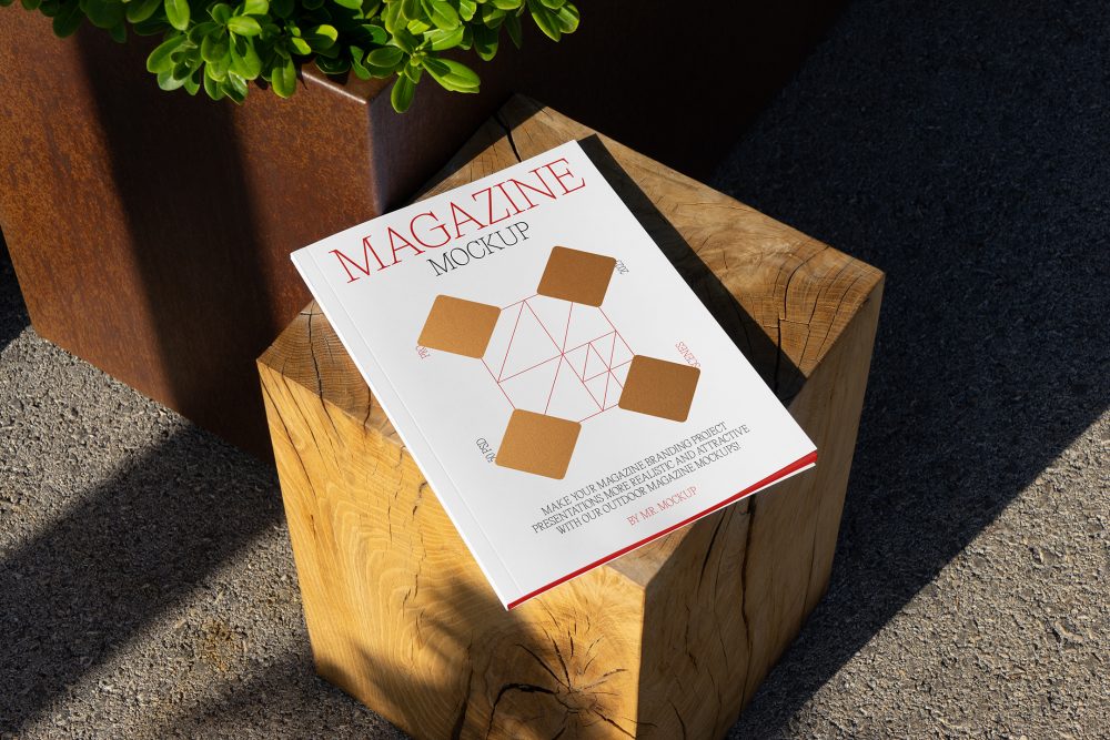 View from above, of outdoor magazine mockups with simple minimalist design in black and red color, serif typography, and diamond foil pattern laying on wooden square.
