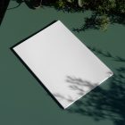 View from above, of a white outdoor magazine mockup laying on a green table.