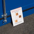 Front view, of outdoor magazine mockups with simple minimalist design in black and red color, serif typography, and square foil pattern resist on the blue container color.
