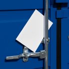 Front view, of a white outdoor magazine mockup lies between a blue container and a silver metal tube.