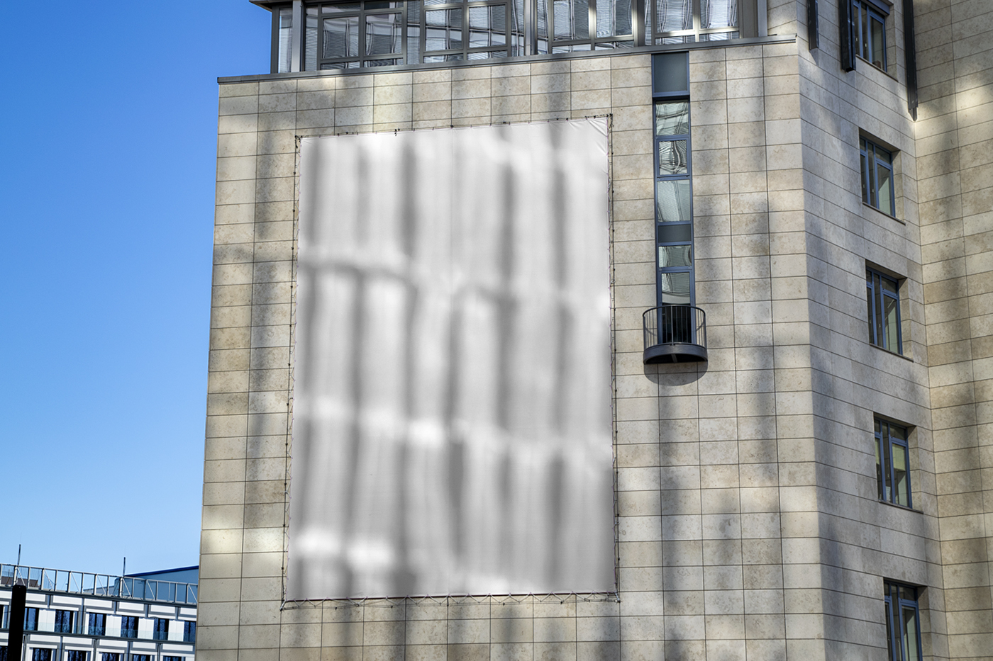 Front view, a White Vertical Billboard Mockup hanging on the building wall.