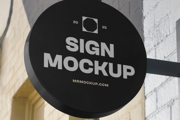 Front view, Circle Signage Attached to Wall Mockup in black color and white, strong design against the brick building.