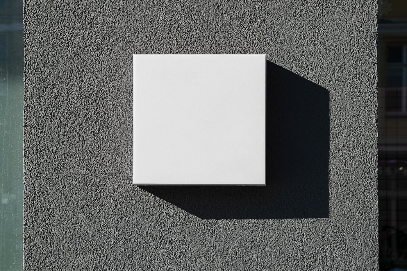 Front view, a White Street Sign Mockup attached to the gray wall.