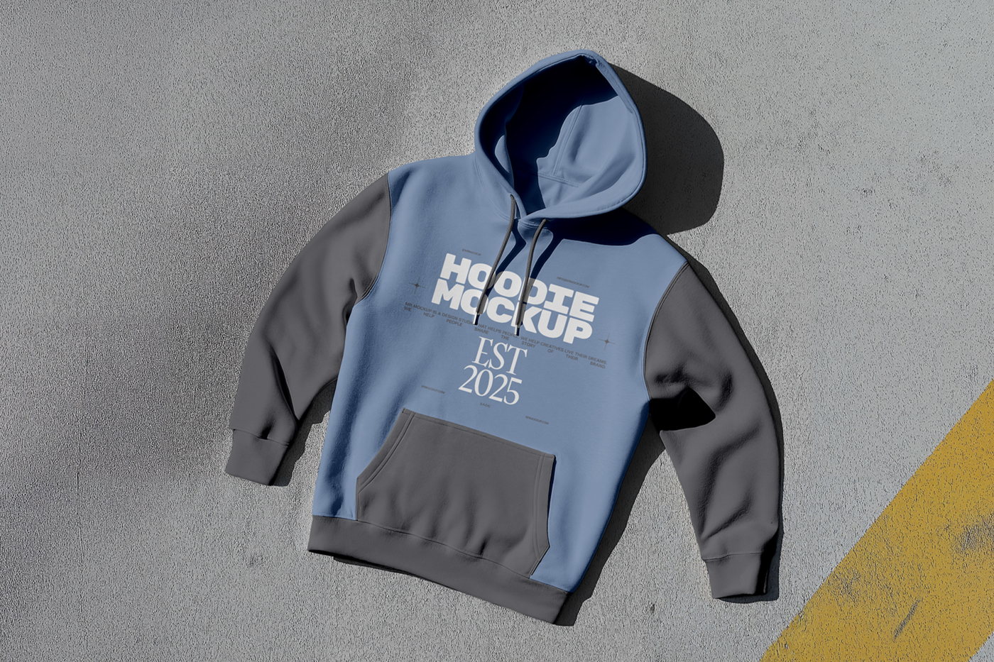 Laying a Hoodie Mockup with a dark gray and navy color on the gray color floor.