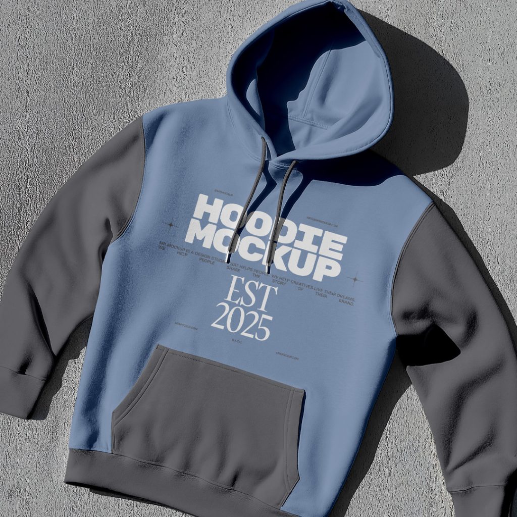 Laying a Hoodie Mockup with a dark gray and navy color on the gray color floor.