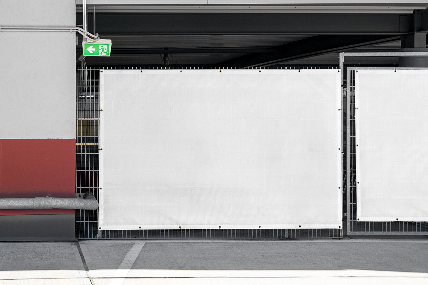 Front view, a White Urban Banner Mockups hanging on the parking fence.