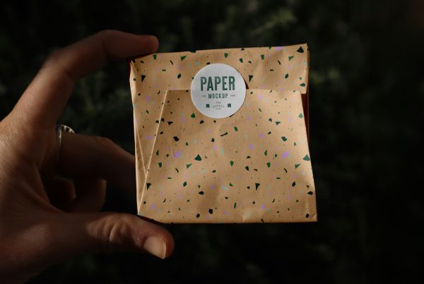 Front view, Wrapping Paper Package Mockup with circle sticker and terrazzo design patter against black background.