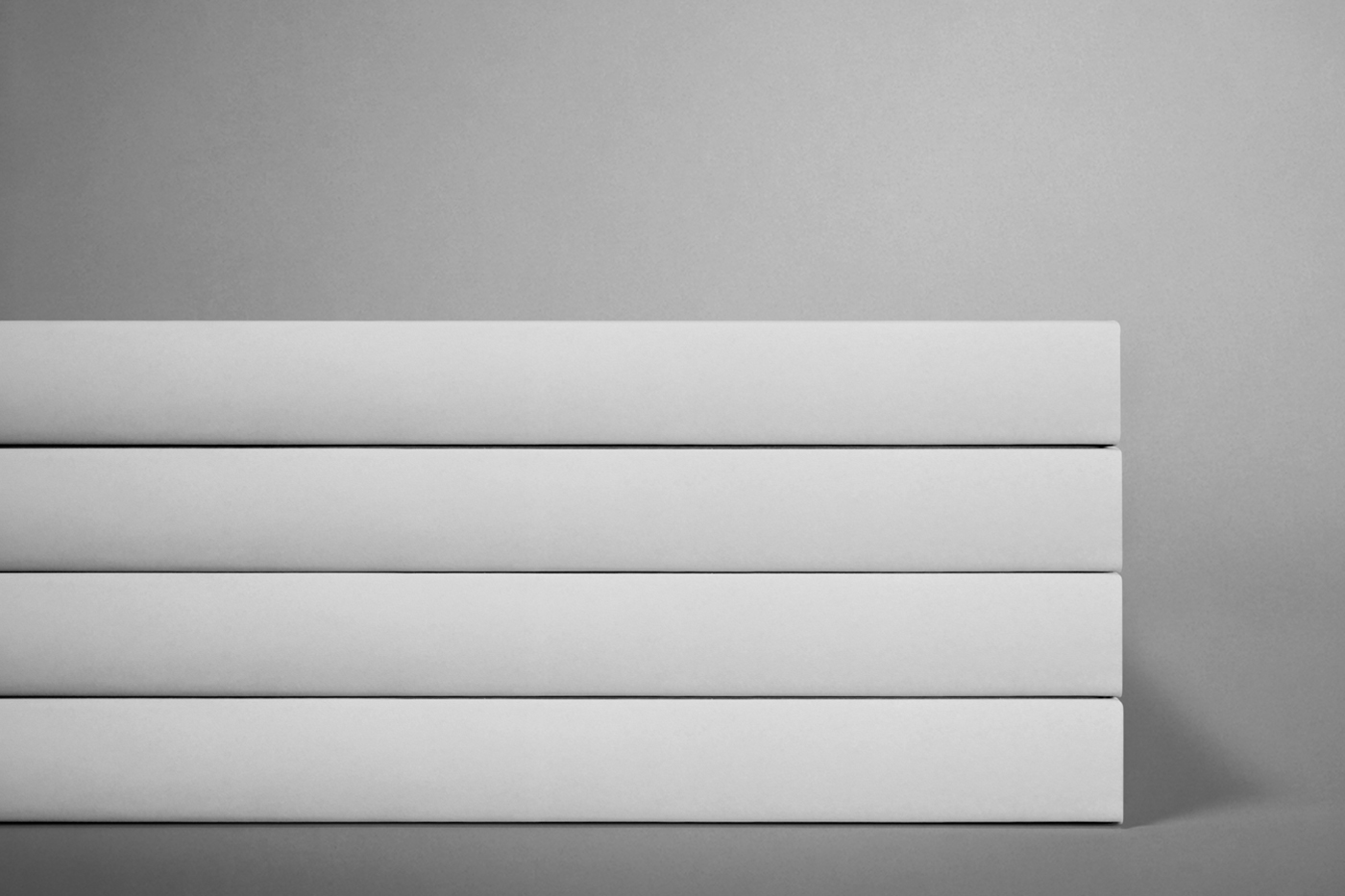 Front view, placed one on top of the other four white books mockup lying on the shelf.